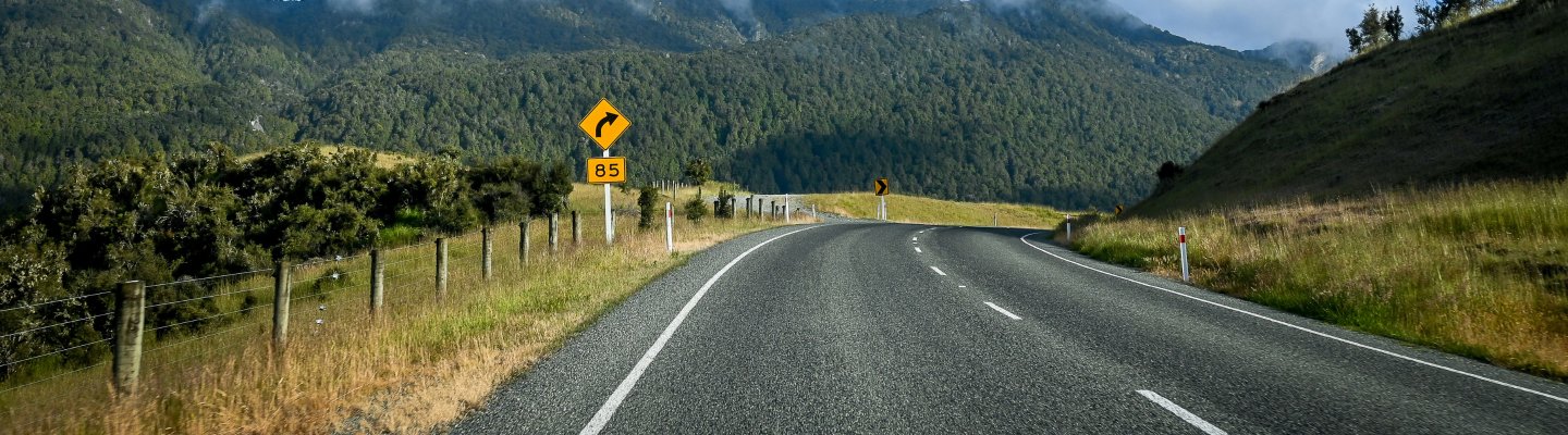 A road featuring a yellow warning sign, indicating caution or a specific traffic condition ahead.